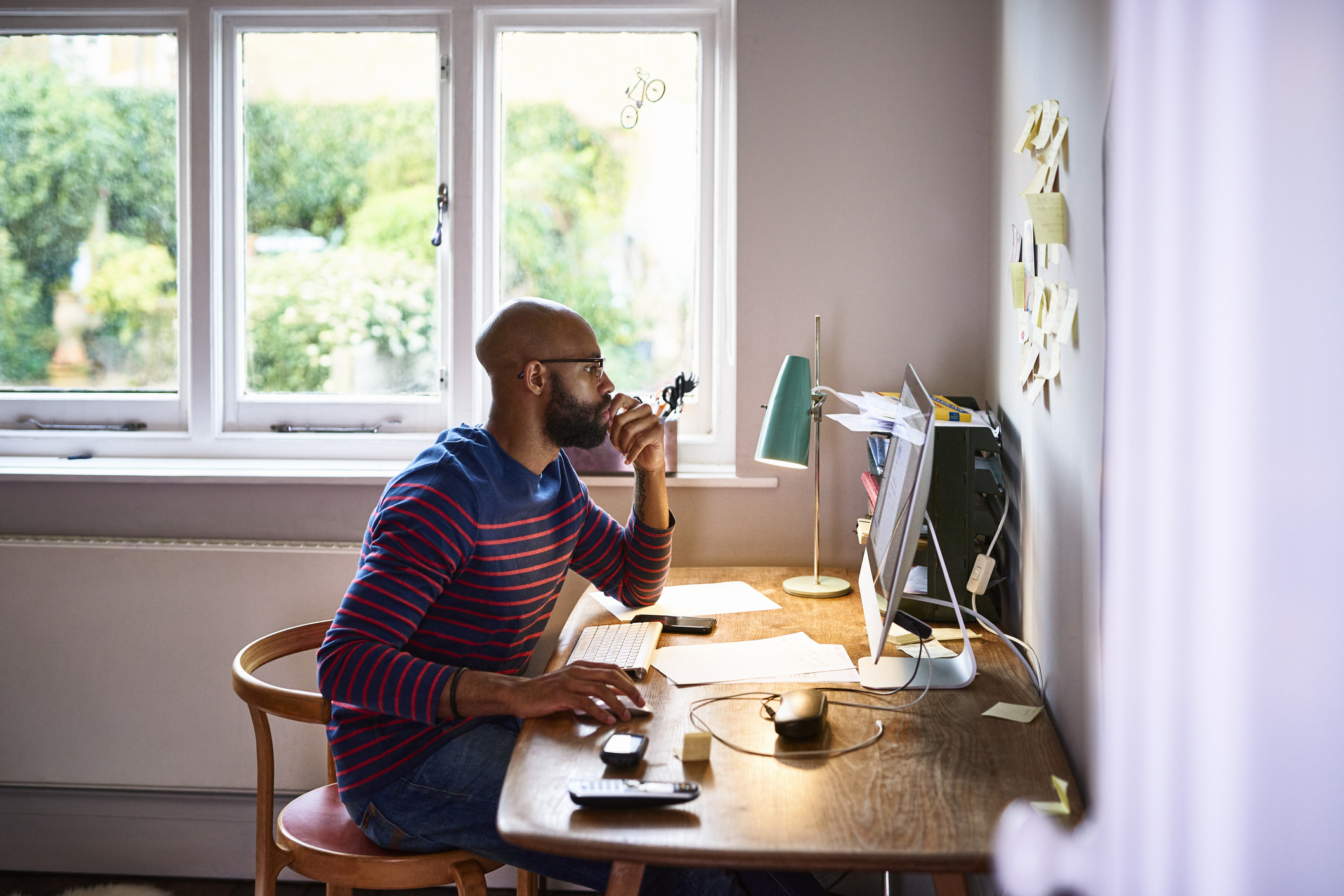 Black male sat at a desk building a website online with Go Sitebuilder