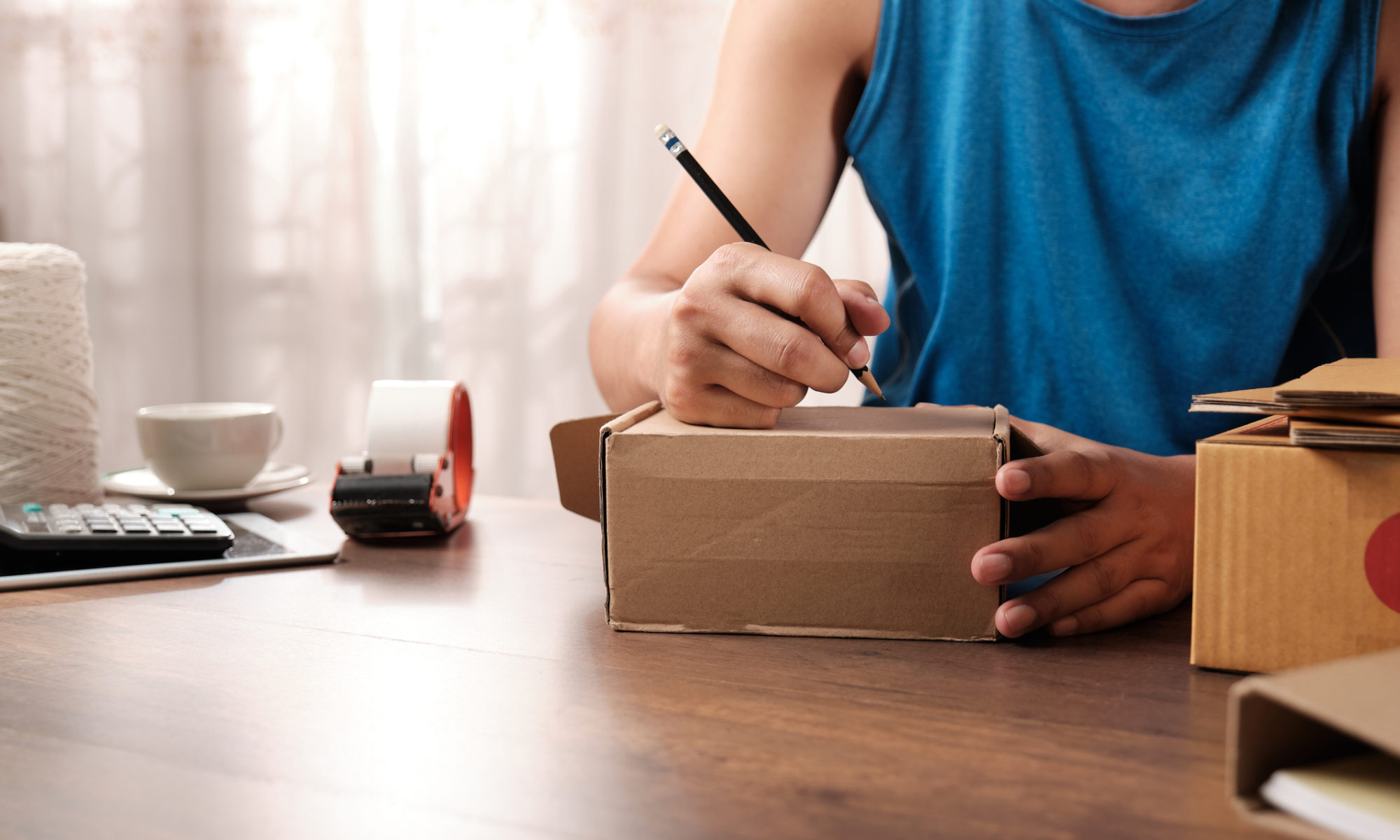 Online store owner writing an address on a package