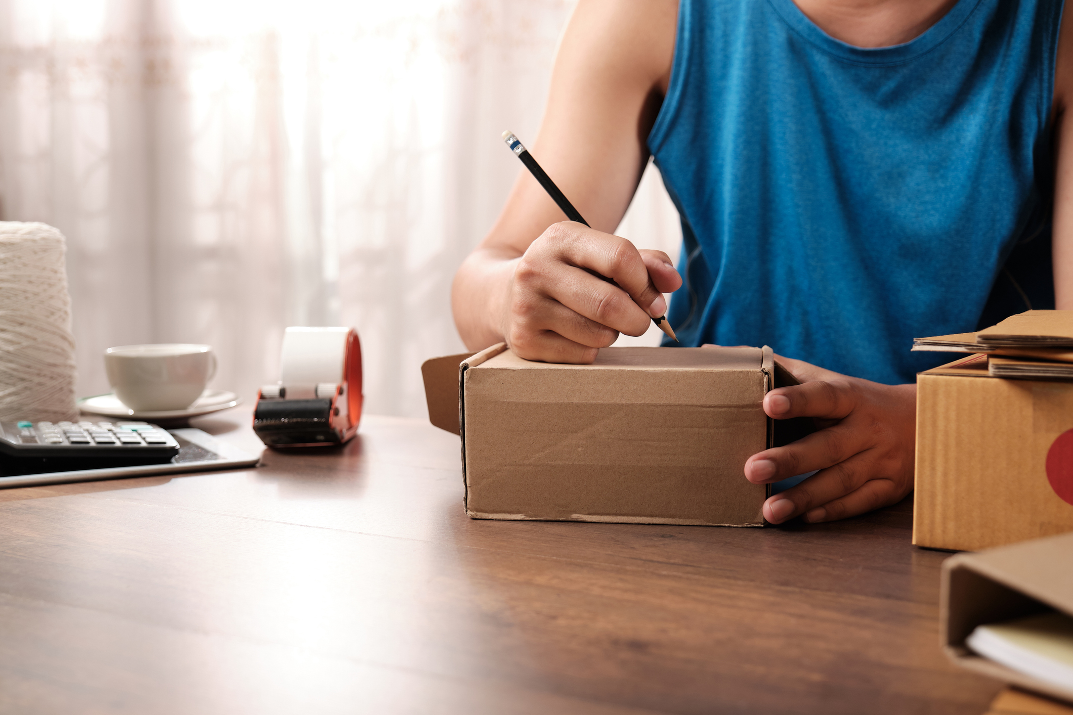 Online store owner writing an address on a package