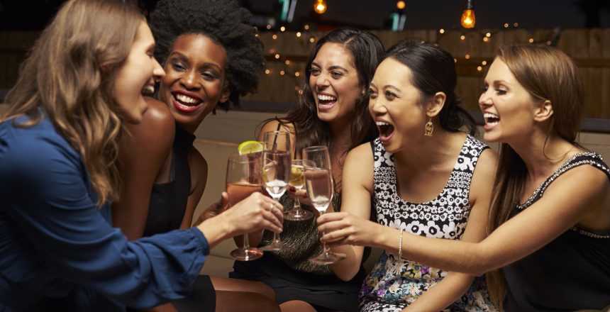 Group Of Female Friends Enjoying Night Out At Rooftop cocktail bar