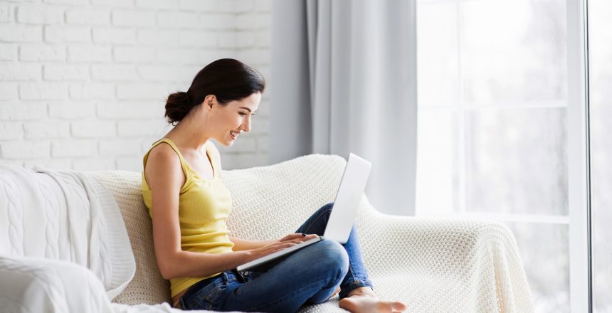 Young woman using laptop at home to find out how to watermark photos