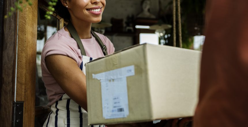 Female business owner accepting a package from a delivery person.